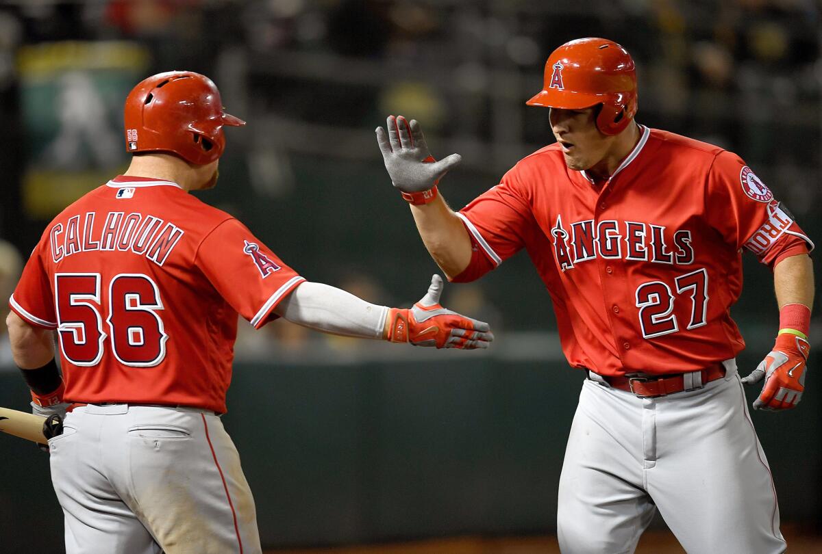 Angels outfielder Mike Trout (27) is congratulated by teammate Kole Calhoun (56) after hitting his first home run of the season.