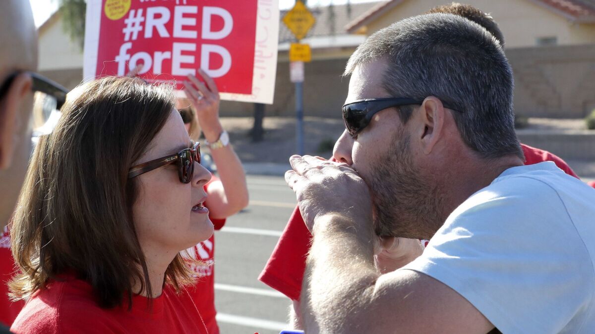 A parent of a Paseo Elementary student shouts at teacher Tammy Custis outside the school in Peoria, Ariz., on Wednesday.