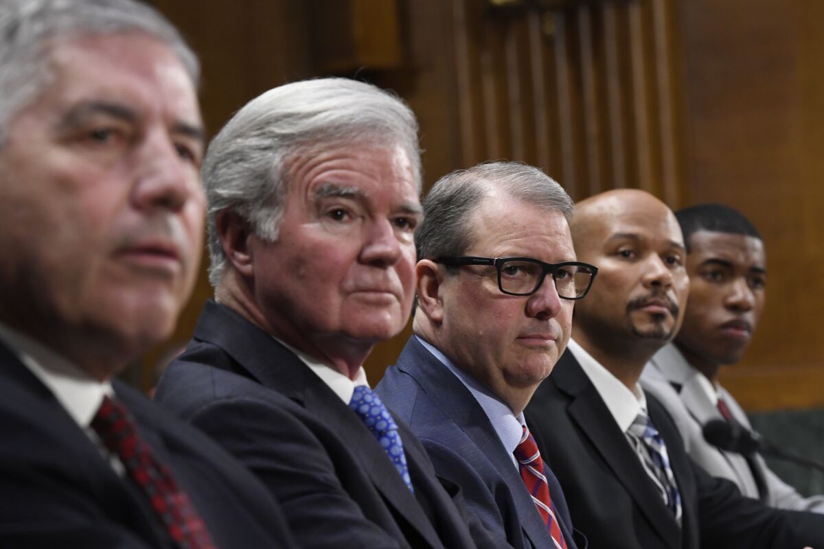 NCAA President Mark Emmert and others listen during a Senate Commerce subcommittee hearing.