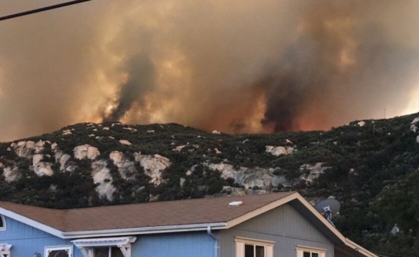 The Valley fire nears an Alpine home on Saturday.