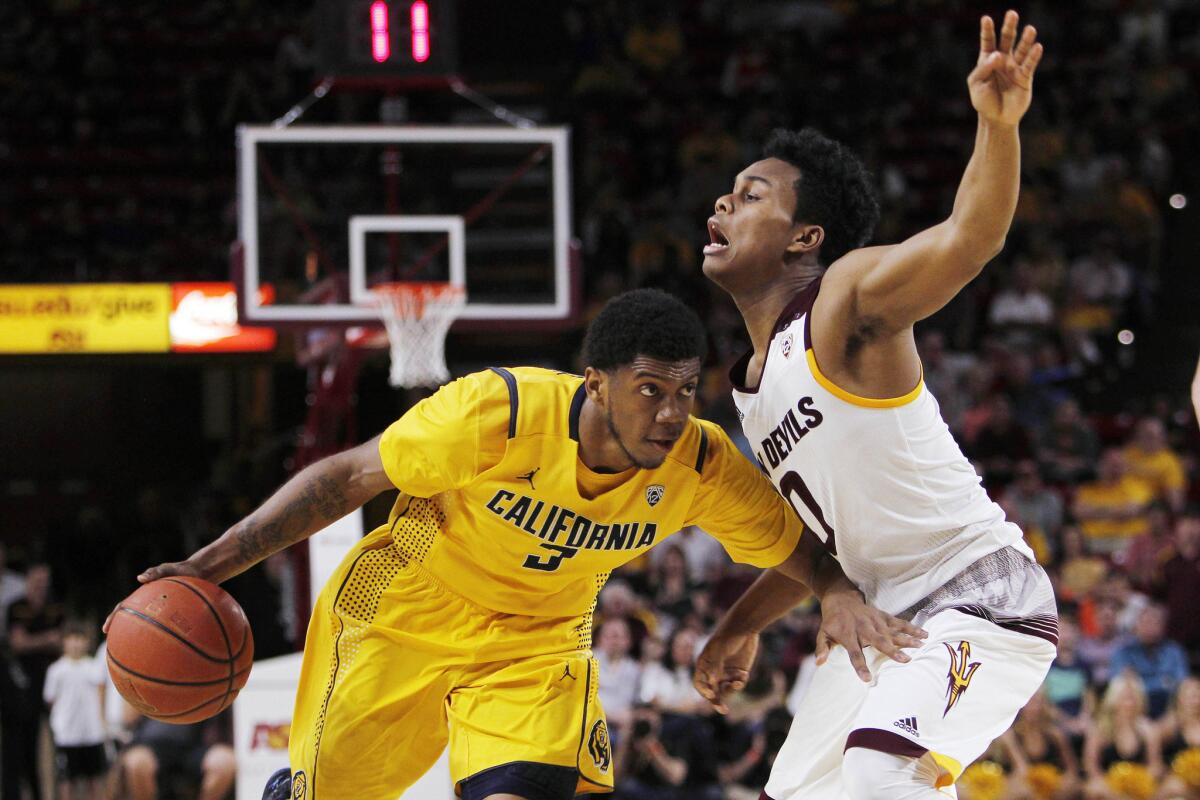 California guard Tyrone Wallace, left, dribbles the ball against Arizona State guard Tra Holder during the second half of a game on March 5.