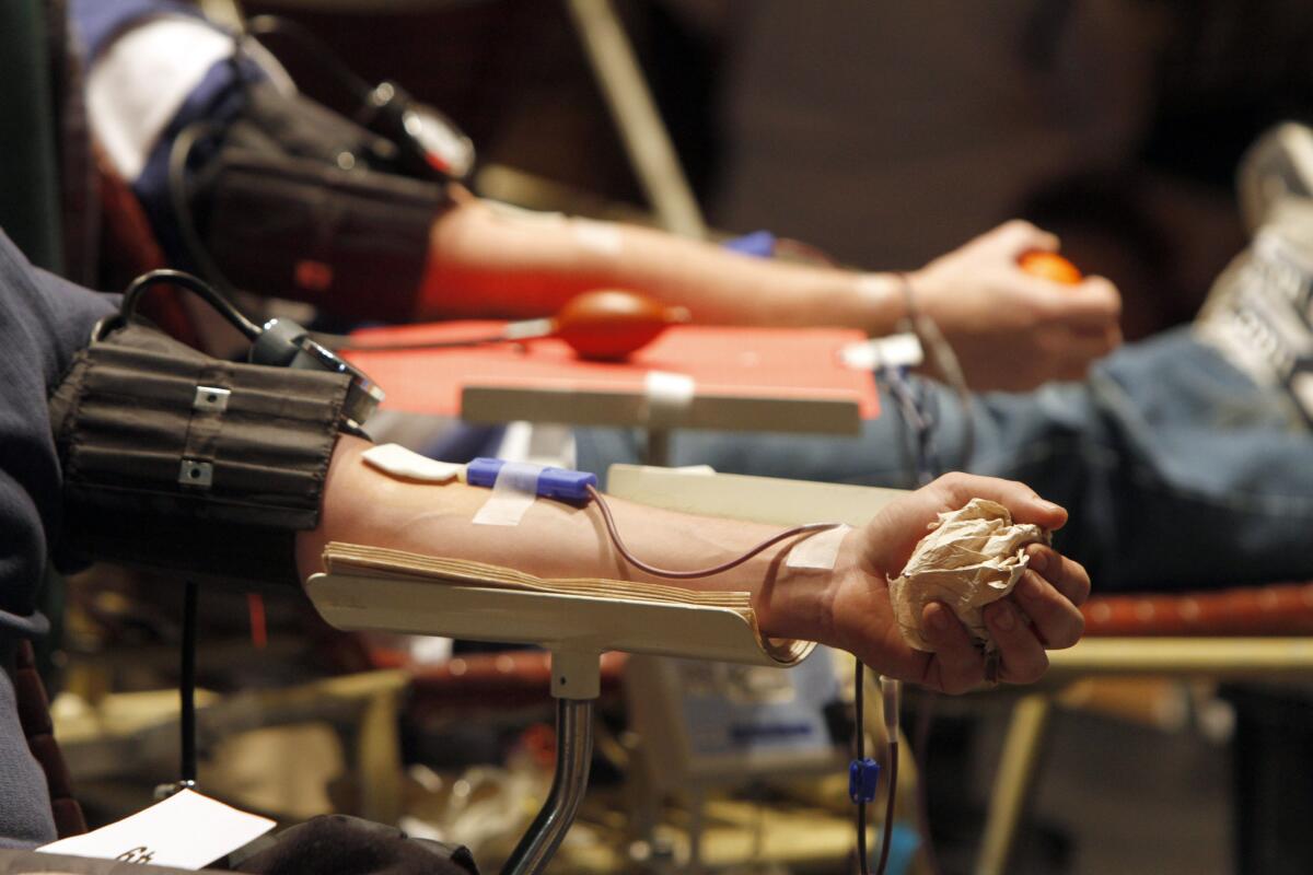 Donors give blood at a blood drive. Gay and bisexual men will be allowed to join them under a new FDA policy announced Monday, but only if they are HIV-free and have abstained from sex with other men for at least a year.