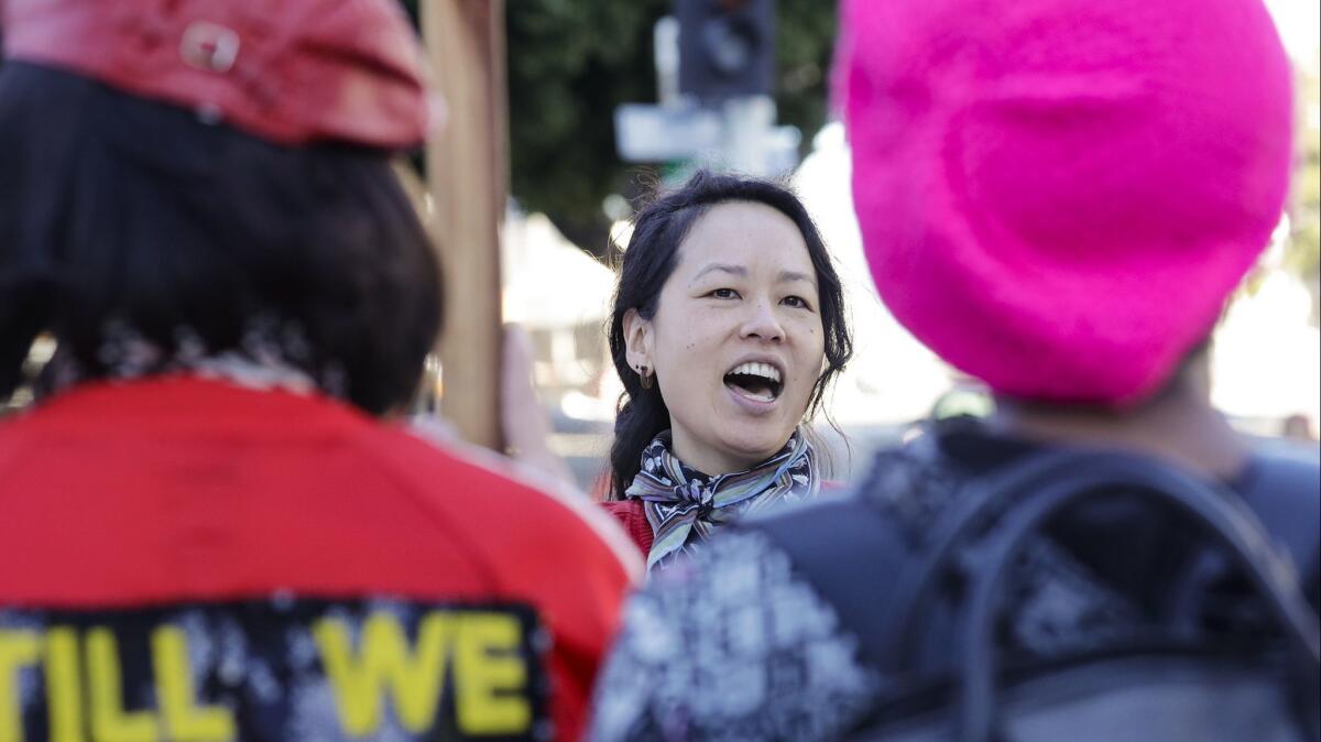 Tany Ling, the volunteer choral director of Community Chorus, leads the group Saturday at the Women's March in downtown L.A.