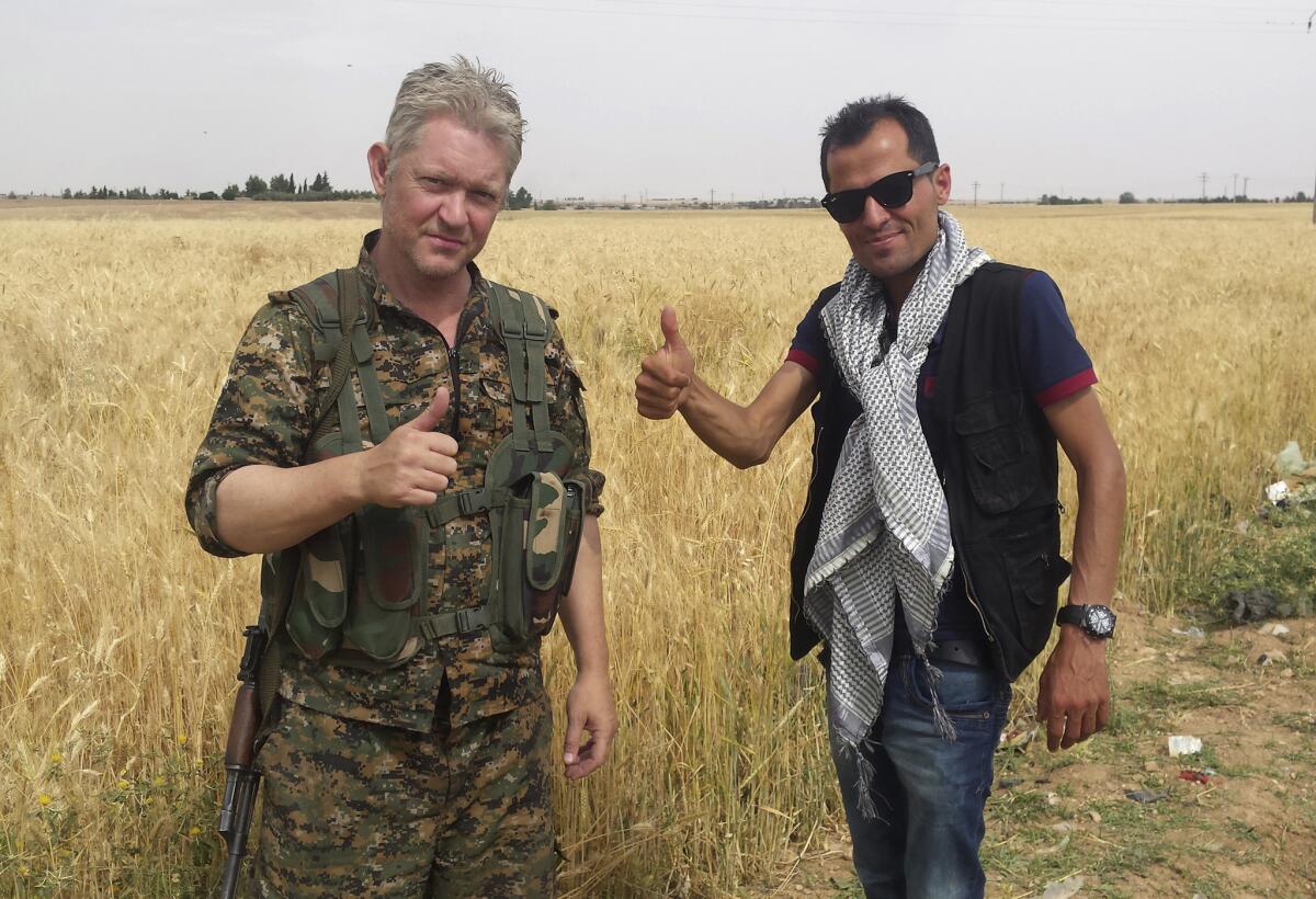 Foto difundida por el periodista curdo Mohammed Hassan, en la imagen a la derecha, el 1 de junio de 2015, acompañado de Michael Enright, un actor británico que ha tenido papeles menores en películas de Hollywood. En un video de combatientes curdos difundido el martes 2 de junio se ve a Enright en una trinchera con curdos que luchan contra el Estado Islámico en Siria. (Mohammed Hassan vía AP )