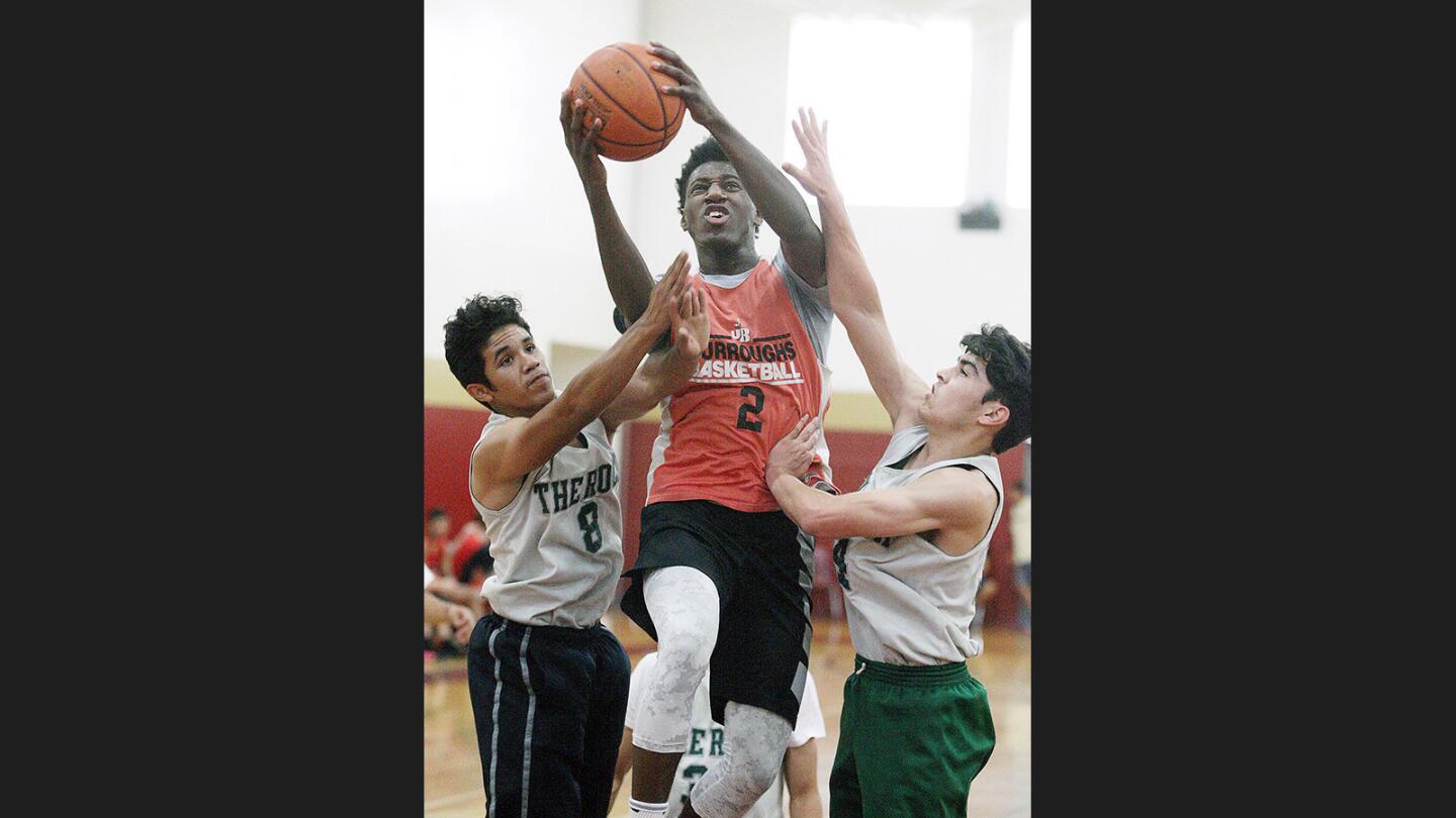 Burroughs Stefon Foster drives between Eagle Rock defenders Chris Hernandez and William Del Pinal in the Glendale College Shootout at GCC in Glendale on Friday, June 23, 2017.