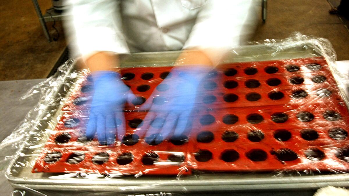 A chef covers a batch of marijuana-infused chocolate truffles in the kitchen at Dixie Elixirs & Edibles in Denver. Officials in the city are set to allow social marijuana use at businesses.