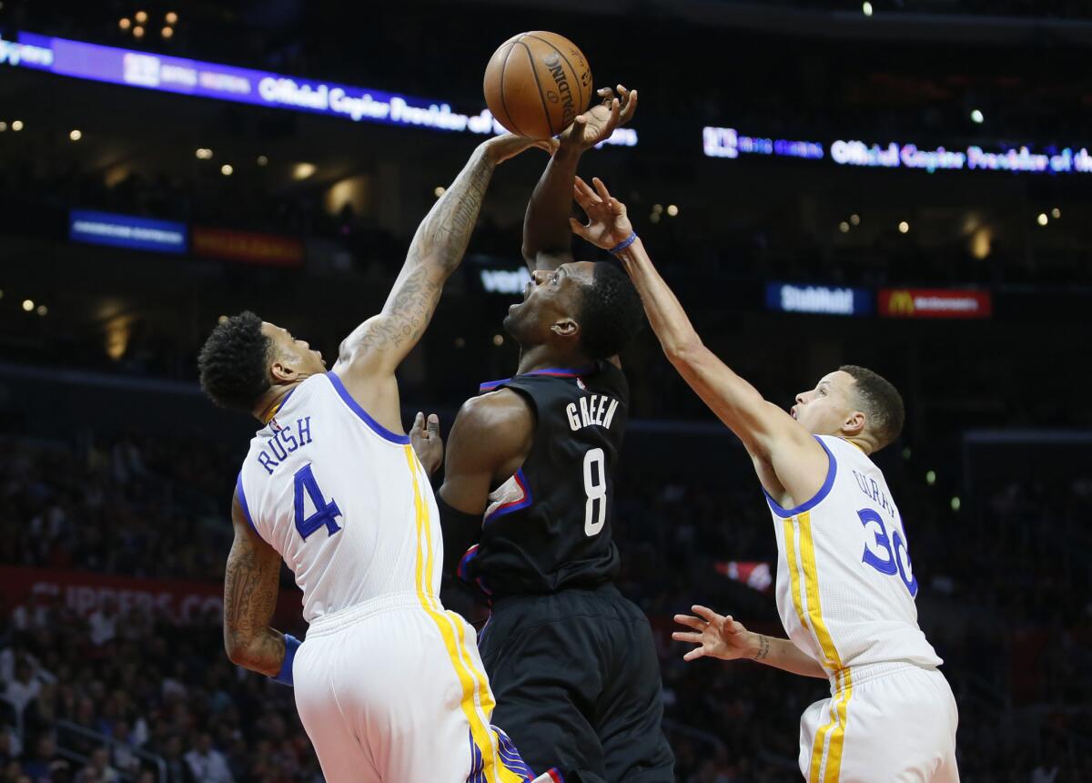 Clippers forward Jeff Green tries to get a shot off in between Warriors defenders Brandon Rush (4) and Stephen Curry (30) during the first half.