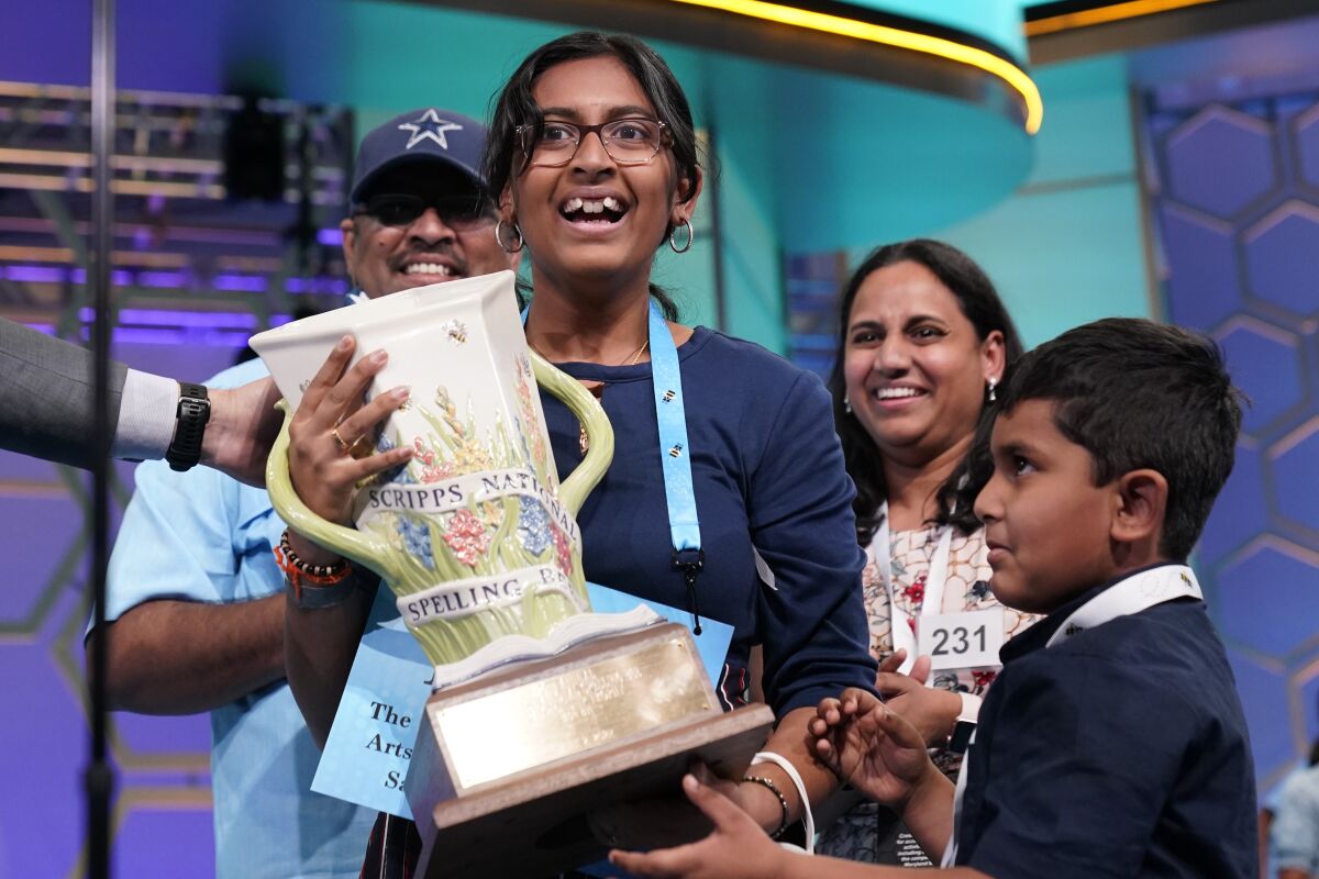 Harini Logan, 14, from San Antonio, Texas, celebrates winning the Scripps National Spelling Bee with her family, brother Naren Logan, right, mom Rampriya Logan, second from right, and dad Logan Anjaneyulu, left, Thursday, June 2, 2022, in Oxon Hill, Md. (AP Photo/Alex Brandon)