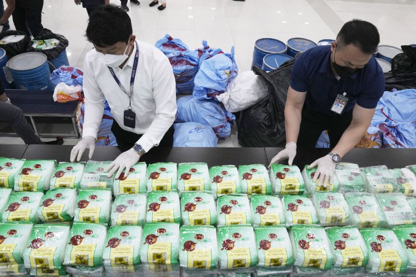 Thai officers display seized crystal methamphetamine which were disguised as packages of tea during a news conference in Bangkok, Thailand, Thursday, June 1, 2023. The huge trade in illegal drugs originating from a small corner of Southeast Asia shows no signs of slowing down, the United Nations Office on Drugs and Crime warned Friday. (AP Photo/Sakchai Lalit)