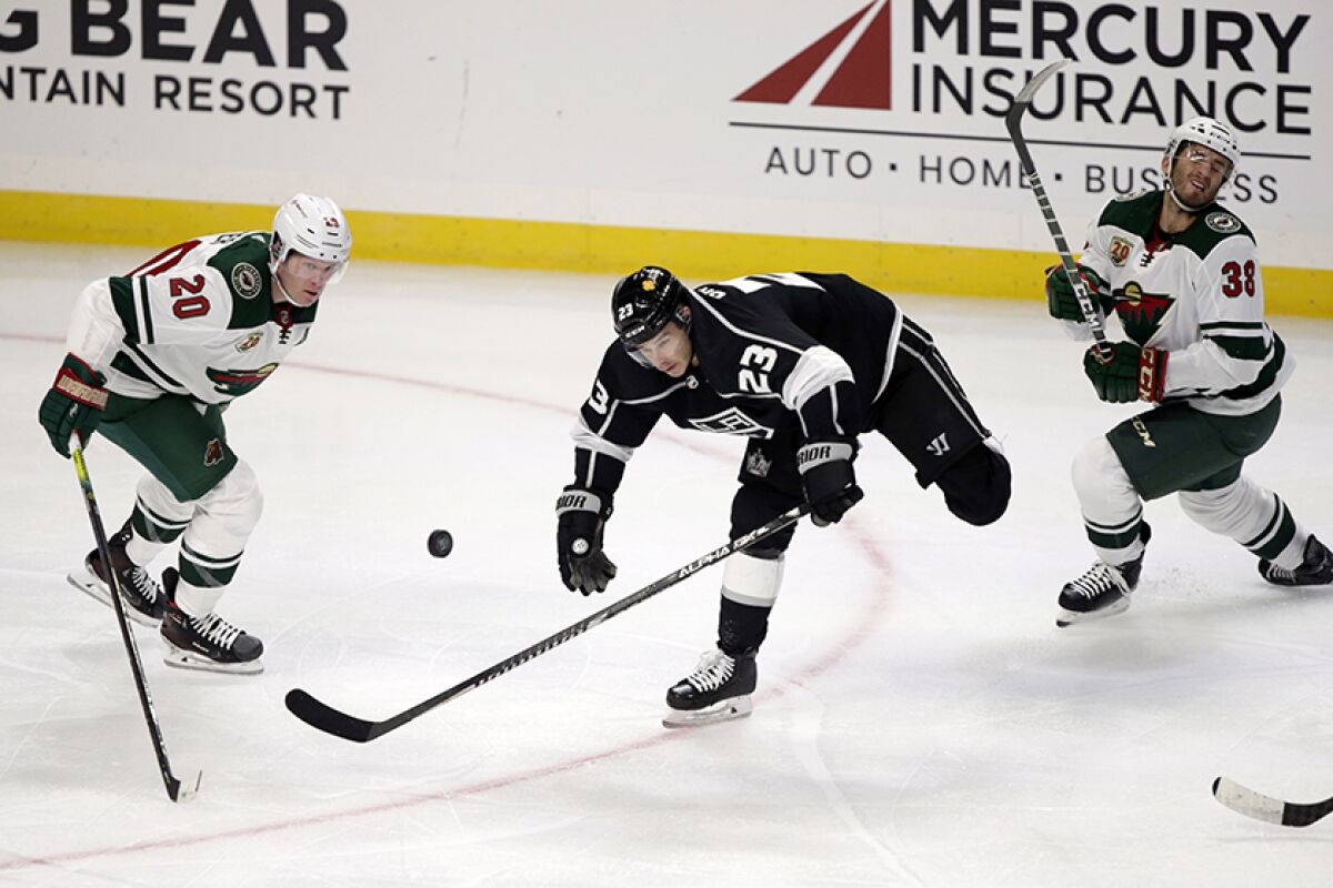 The Kings' Dustin Brown, center, battles for the puck during Thursday's game.