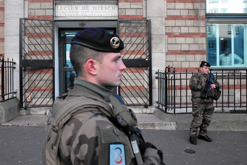 French soldiers secure the entrance to a Jewish school in Paris on Jan. 14 as part of the security plan after last week's attacks by Islamist militants.