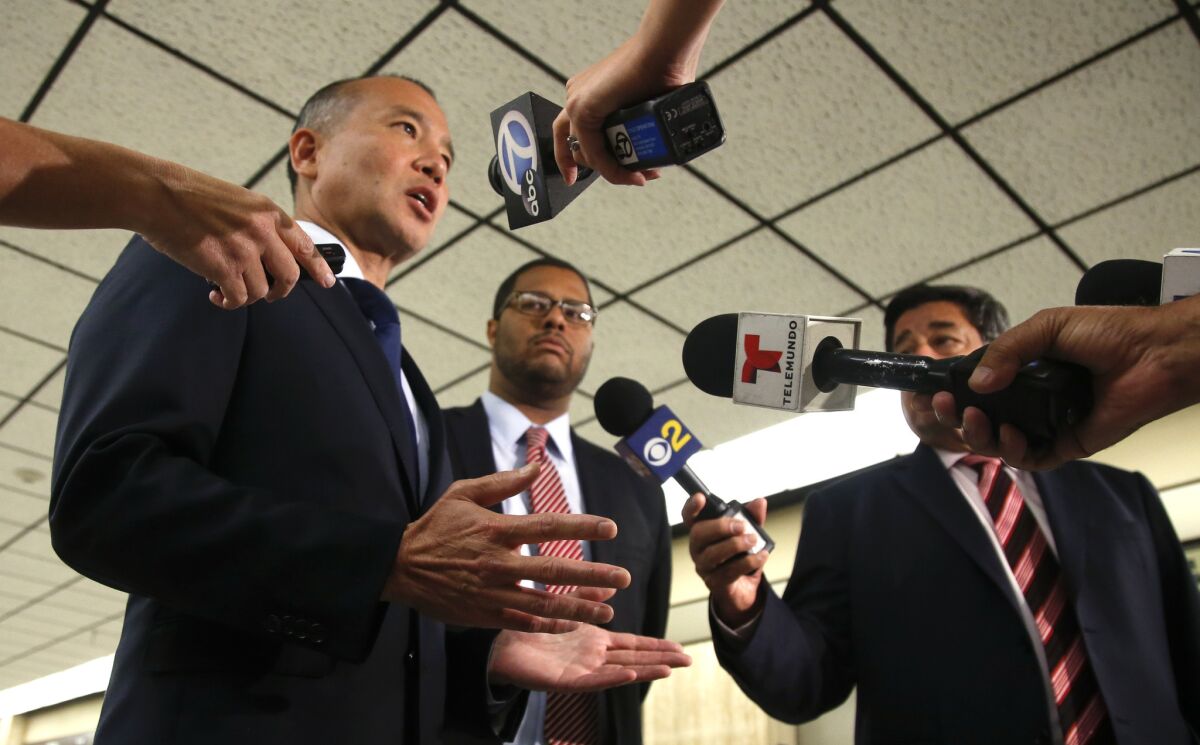 Prosecutors, Hoon Chun, left, assistant head deputy with the district attorney's consumer protection division, and Deputy Dist. Atty. Christopher Curtis talk with reporters about the settlement reached Wednesday with Bumble Bee Foods.