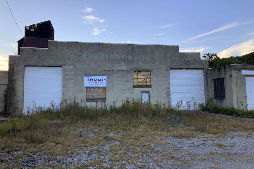 Trump-Pence sign hangs on a building off of Main Street in Monongahela, Pa., on Sept. 23, 2022. The sign is a lasting vestige of the campaign fervor that roused voters to the polls, including many who still believe the falsehood that the former president didn’t lose the 2020 election and hope he will run again in 2024. (AP Photo/Lisa Mascaro)