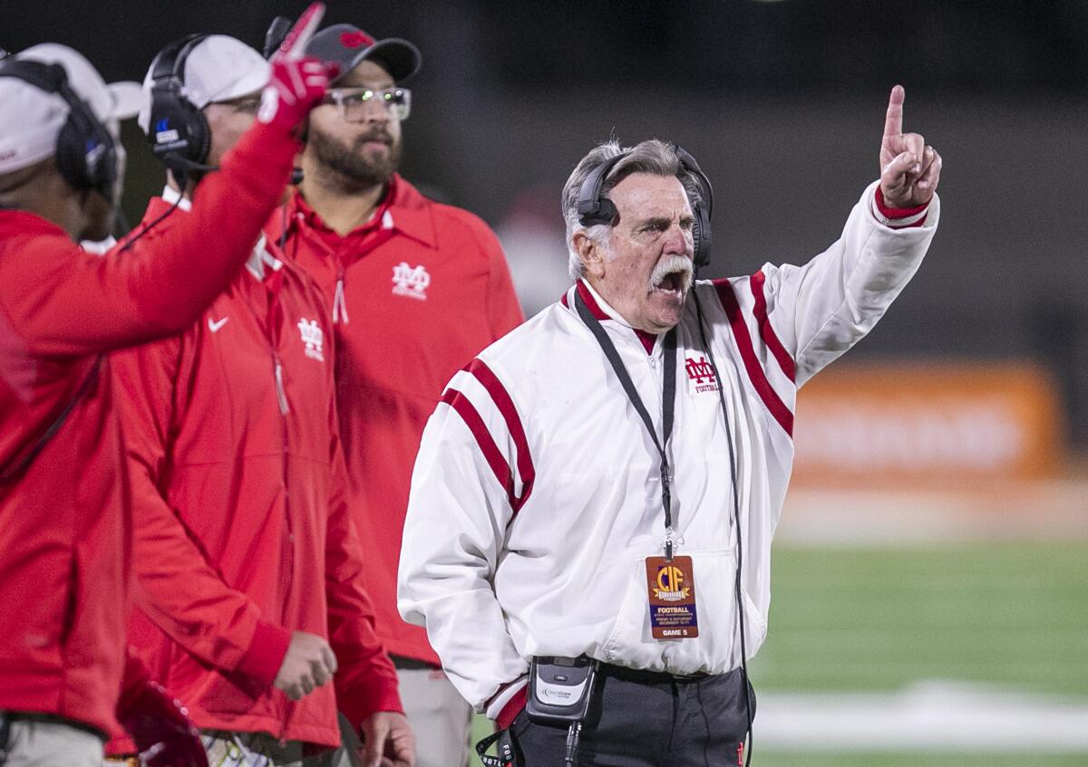 Mater Dei coach Bruce Rollinson signals to his team on the field from the sideline.