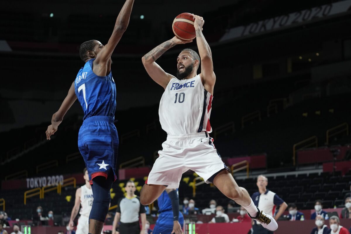 France's Evan Fournier (10) shoots over United States' forward Kevin Durant (7) during a men's basketball preliminary round game at the 2020 Summer Olympics, Sunday, July 25, 2021, in Saitama, Japan. (AP Photo/Eric Gay)