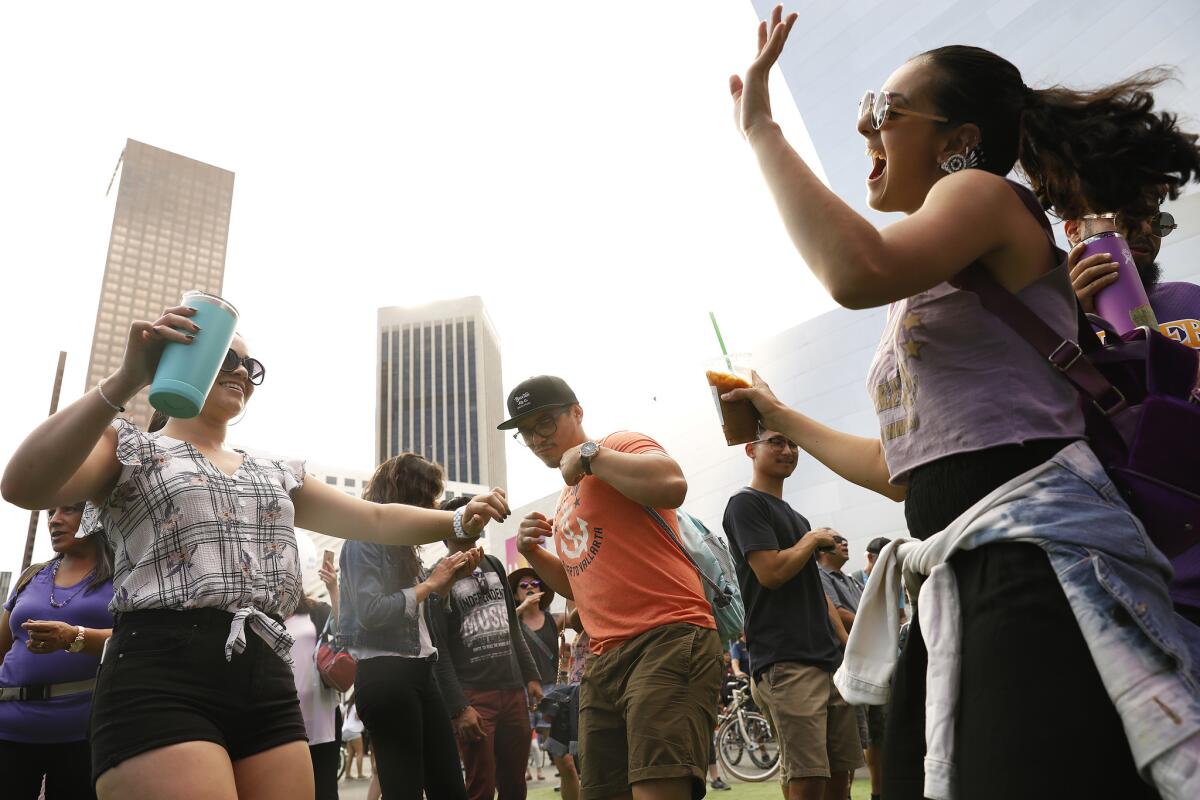 Carolina Restrepo, 25, from left, Javier Negrete, 25, and Carla Contreras, 23, dance in front of Disney Hall in downtown Los Angeles during LA Phil 100 x CicLAvia: Celebrate LA!, a day-long, eight-mile musical street fair extravaganza.