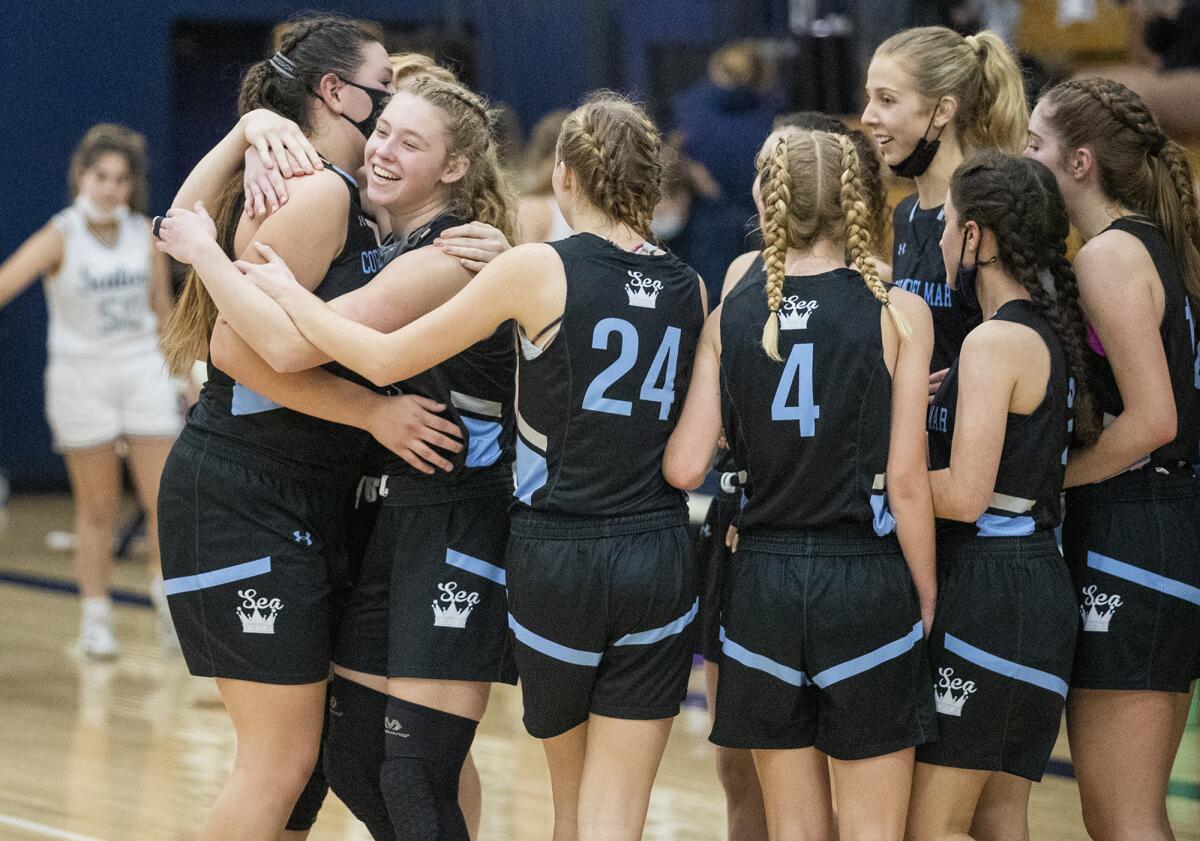 The Corona del Mar girls' basketball team celebrates after beating Newport Harbor during the Battle of the Bay game.