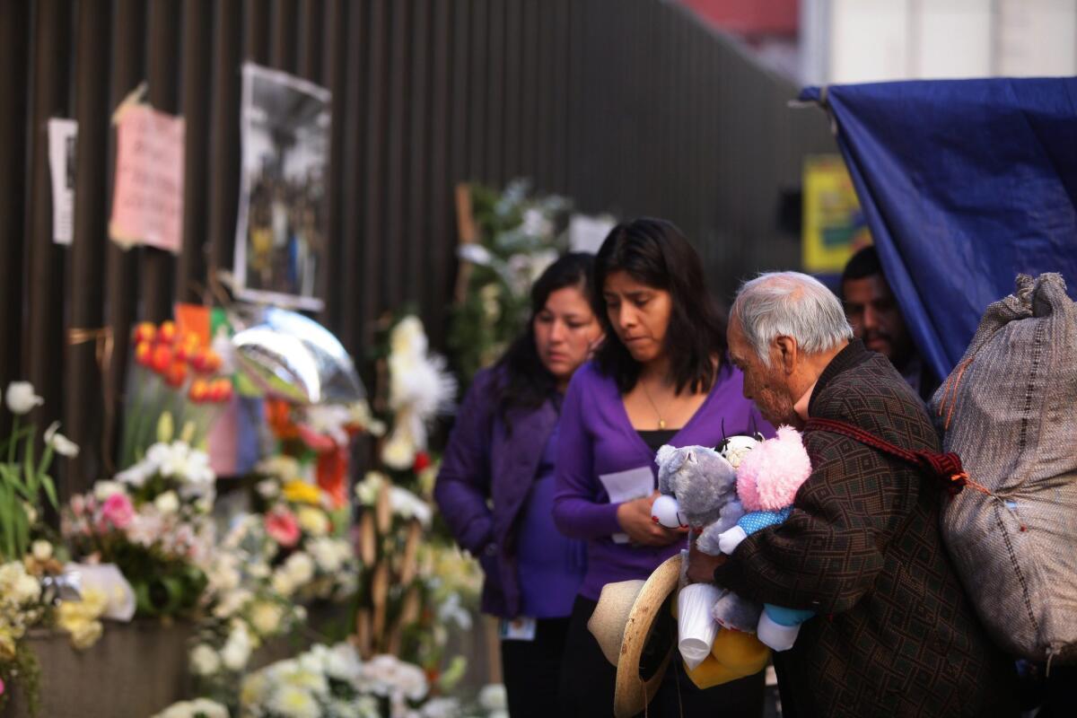 Employees of oil company Petroleos Mexicanos, or Pemex, leave flowers as they return to work Wednesday in the complex where a deadly explosion occurred last week.