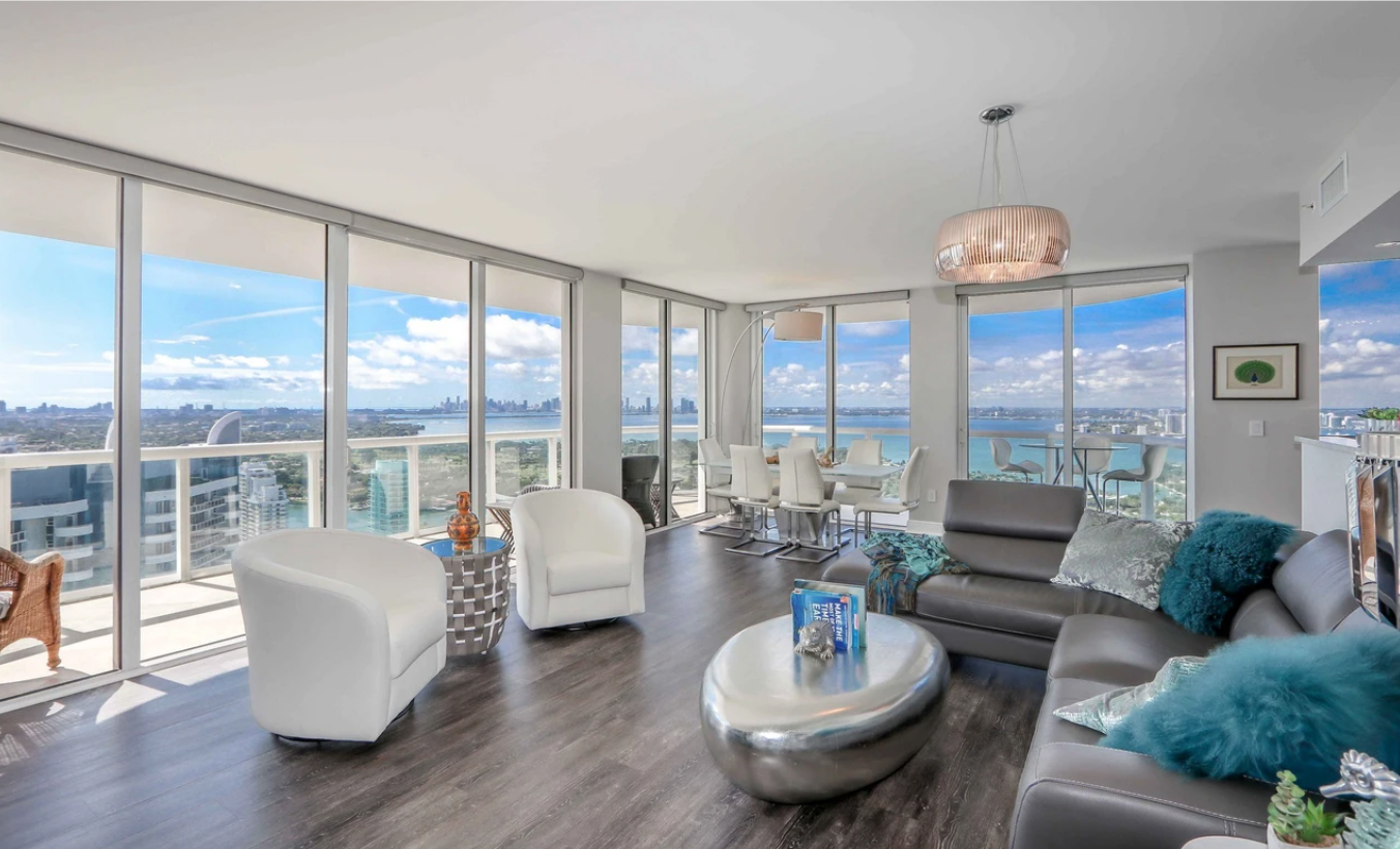 The two-bedroom unit overlooks the ocean from floor-to-ceiling windows and a wraparound balcony.