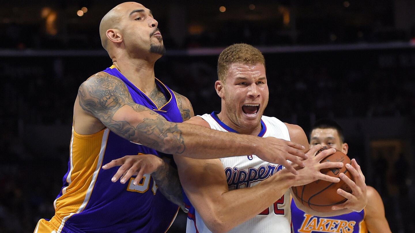 Clippers forward Blake Griffin is wrapped up by Lakers center Robert Sacre. Griffin finished with 27 points, nine rebounds and eight assists in the Clippers' 114-89 win over the Lakers in January.