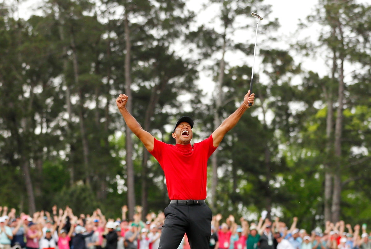 Tiger Woods stretches his arms in the air and celebrates after winning the 2019 Masters.