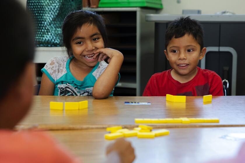 LAUSD’S hope is that keeping kids on track at a young age will help prevent later learning gaps. Above, Betsy Alarcon and Danny Marroquin play a math game.