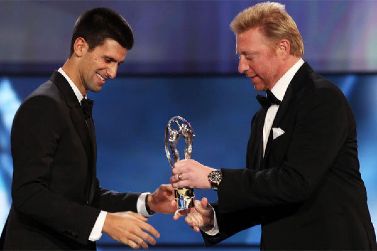 Boris Becker presents Novak Djokovic a trophy at the 2012 Laureus World Sports Awards in London.