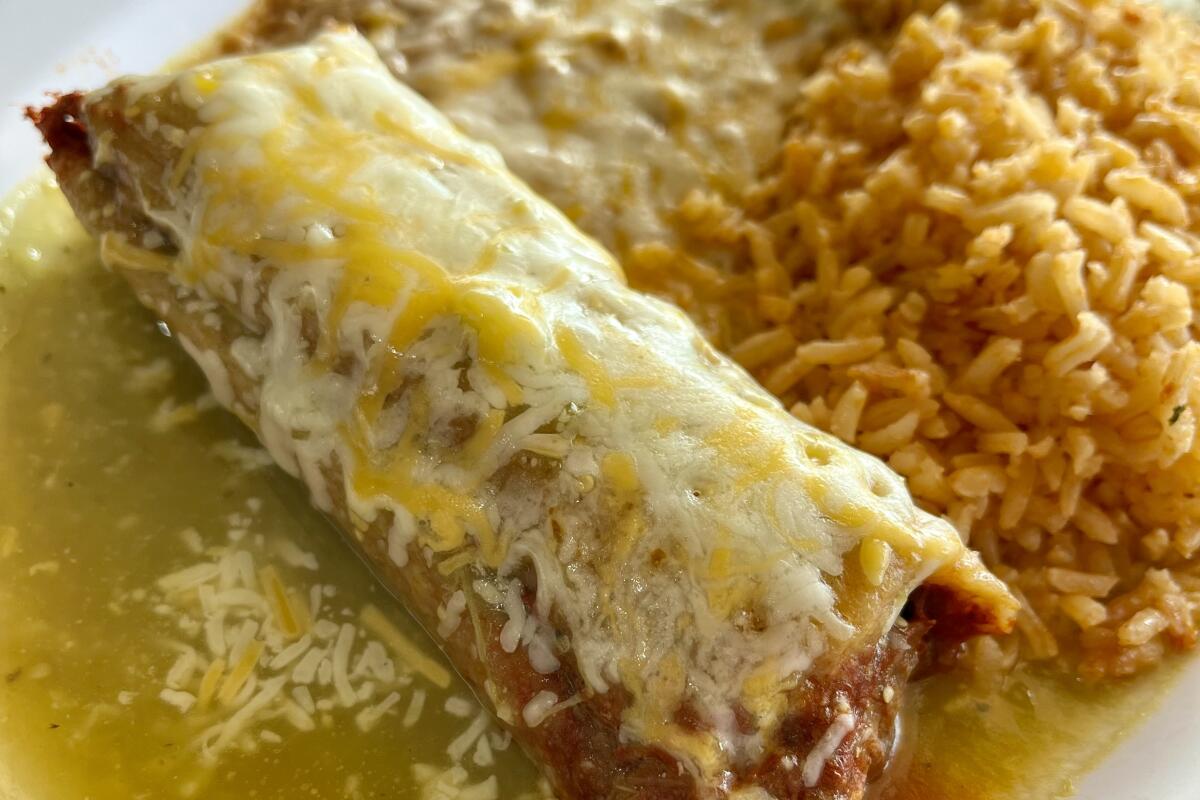 Pork rojo tamale with salsa verde from Tamaleria Rincon Sinaloense in Orange, served with rice and beans.
