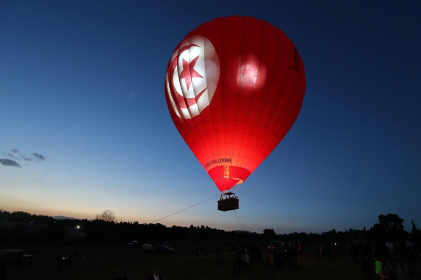 A hot air balloon floats above fields during the Tunisian Balloons Festival in Hammamet, Tunisia on March 22.