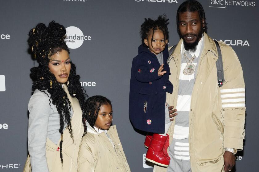 Teyana Taylor and Iman Shumpert and their two daughters pose together at a movie premiere
