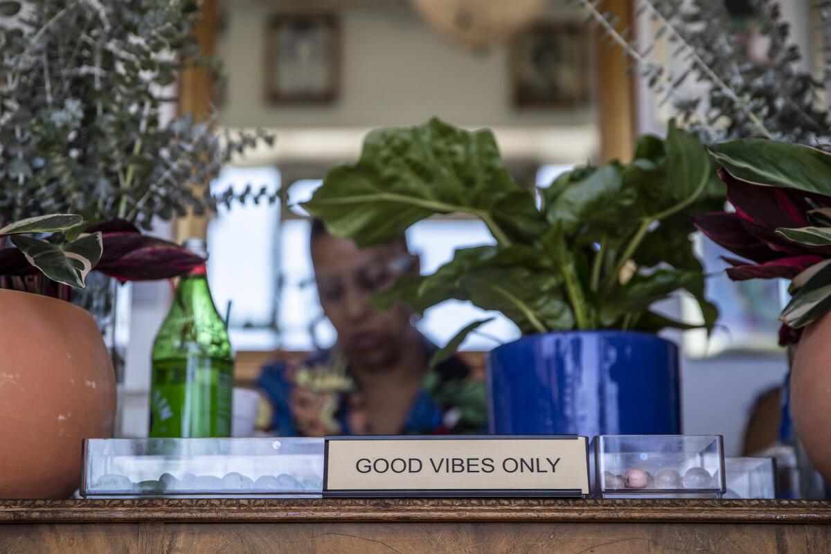 A "Good Vibes Only" sign is on display at Queen boutique.