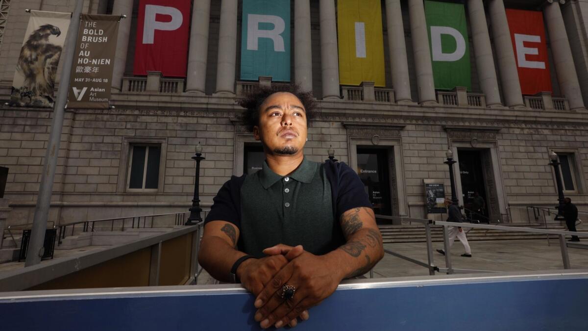 Mason J, 31, a trans queer artist, writer and oral historian, stands in front of the Asian Arts Museum, featuring banners that celebrate Gay Pride. "There's this idea that we're in this bubble here," J said. "But we had three hate crimes in the last few weeks alone."