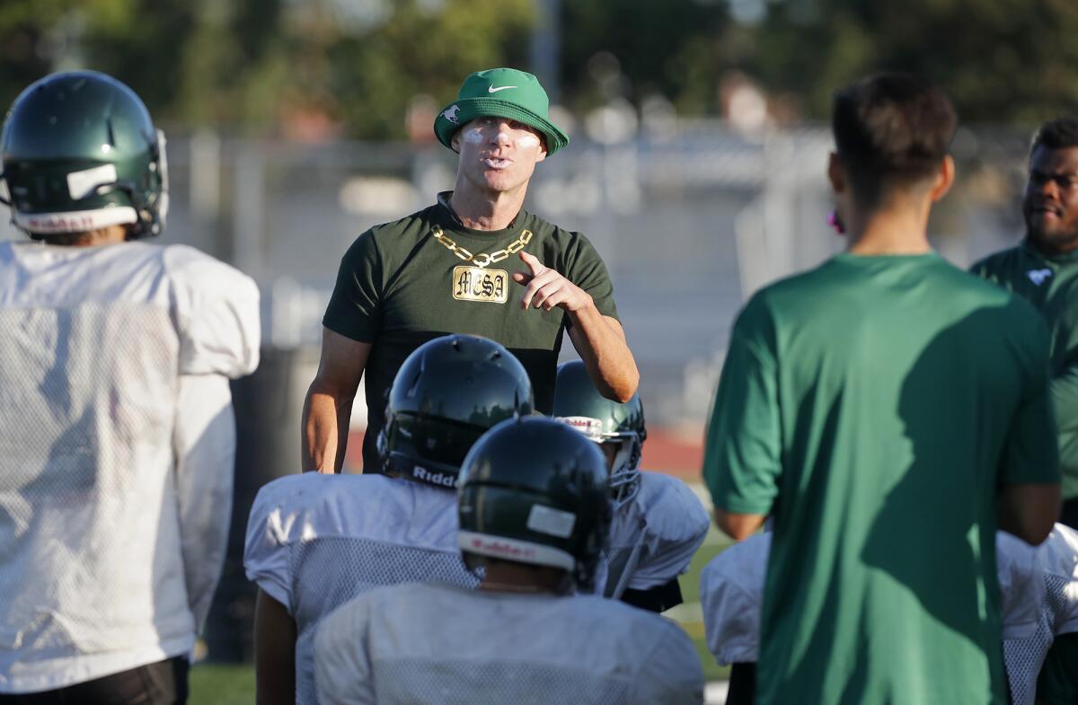 Coach Jimmy Nolan, center, shown during a Costa Mesa practice on Aug. 26, is 2-3 in his first year guiding the Mustangs.