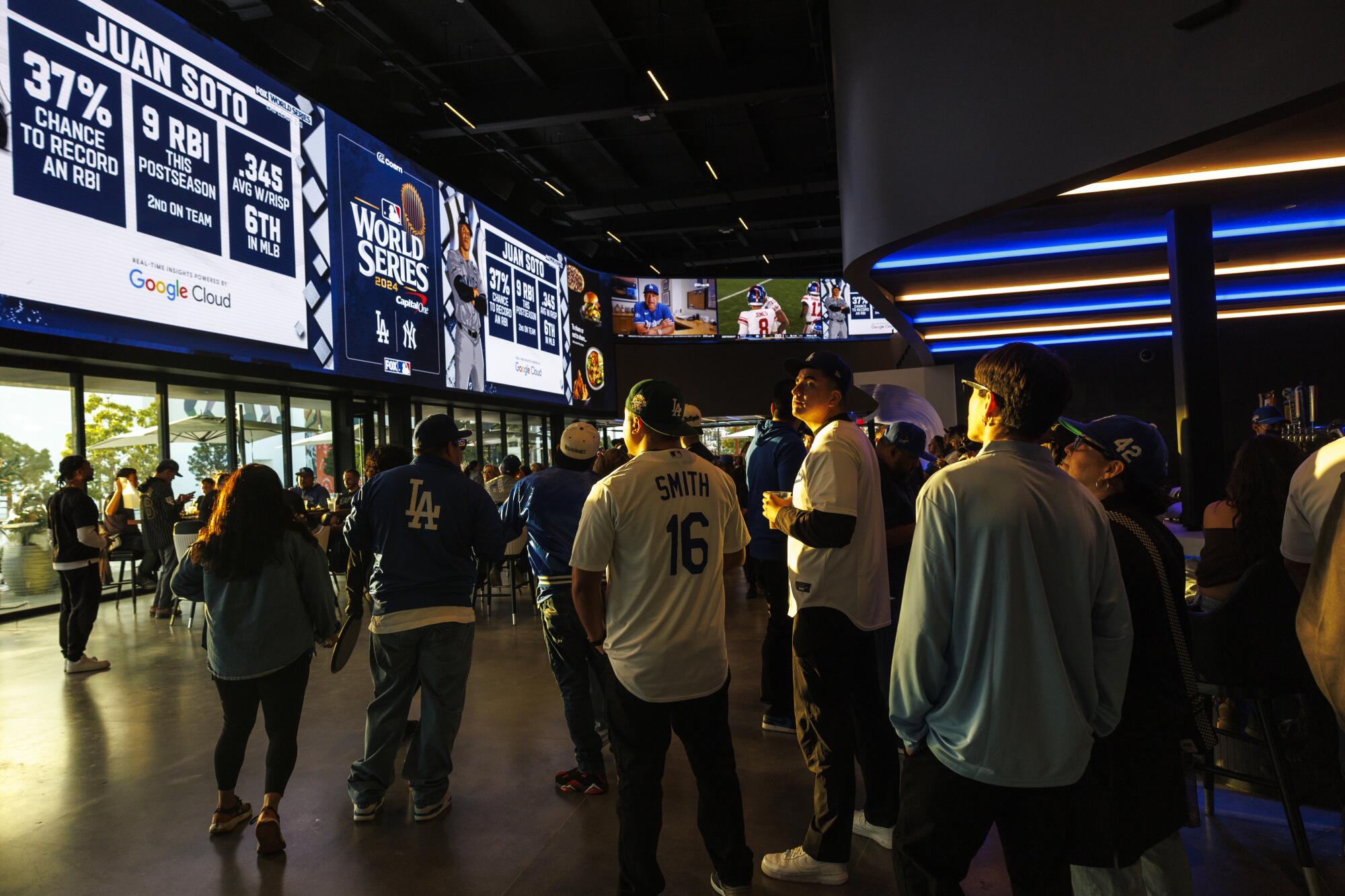 Dodgers hayranları, Dodgers ve Yankees arasındaki Dünya Serisinin 3. Oyununu gösteren dev TV ekranlarını izliyor.