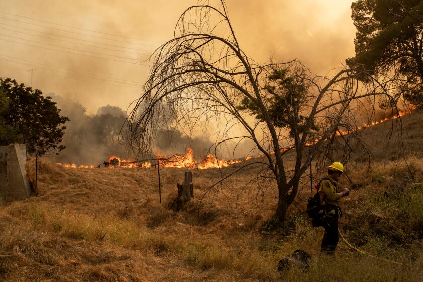 Riverside County, CA - July 15: CalFire crews defend a Beaumont home from the fire raging as they wait for a water-dropping helicopter to make a drop in triple-digit heat in Riverside County Saturday, July 15, 2023. (Allen J. Schaben / Los Angeles Times)