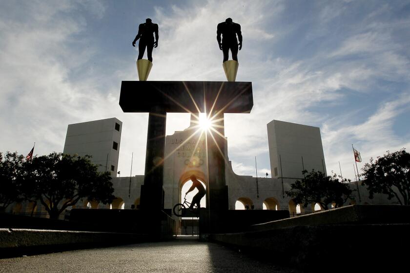 A bicyclist rides in front of the Los Angeles Memorial Coliseum on April 30.