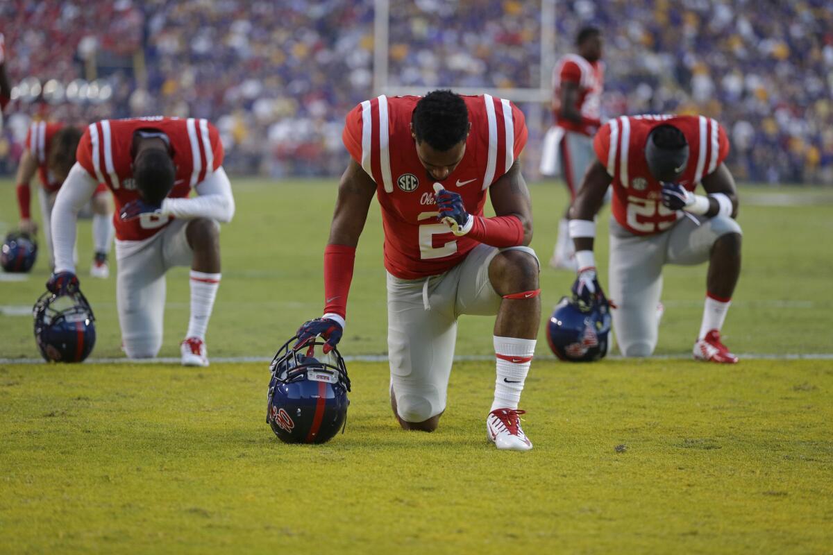 Mississippi players pray in the end zone before an NCAA college football game against LSU in Baton Rouge, La. in 2014. As football season begins, with it comes religion on the gridiron.