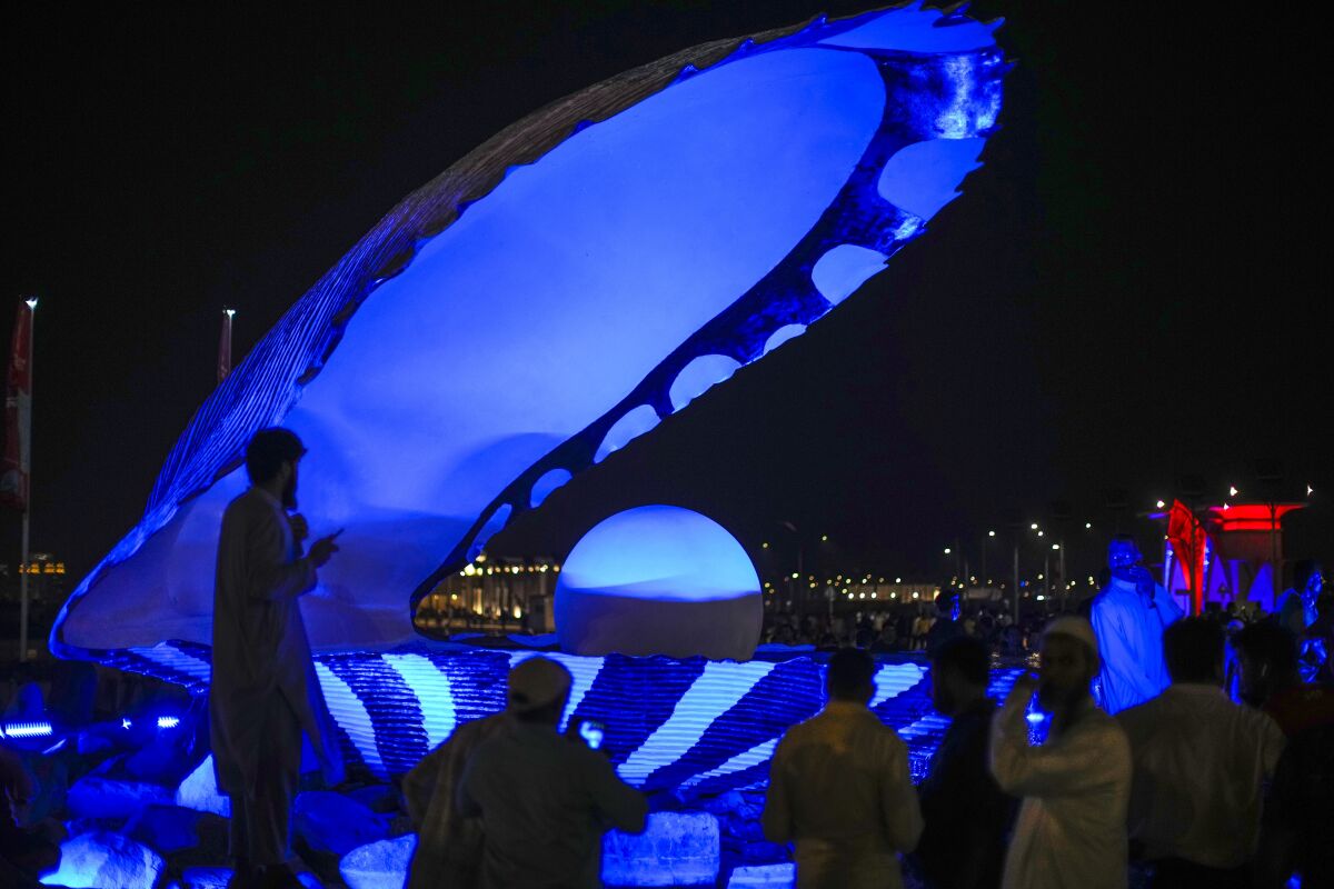 The Pearl monument at the Corniche sea promenade glows blue at night.
