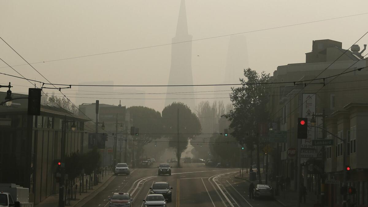 The Transamerica Pyramid is obscured by smoke and haze from wildfires on Friday in San Francisco. The wildfires have forced the postponement of the football game Saturday between Stanford and California.