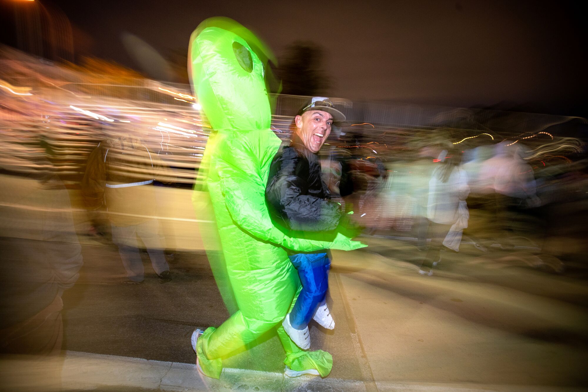 David Rivas, of Harbor City, takes an early-morning run in his alien costume, with the South Bay Runners Club,
