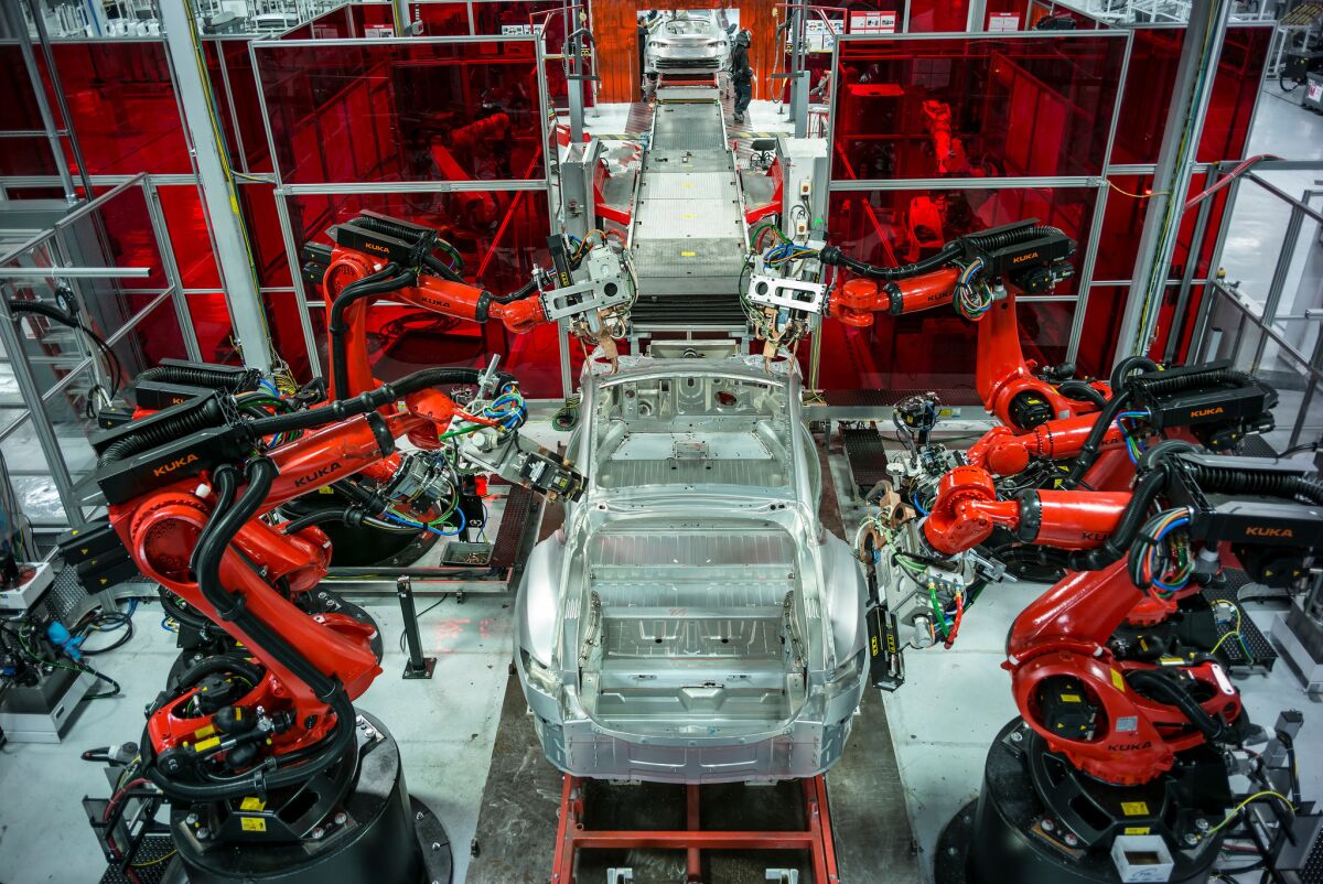 Robots build Teslas at a factory in Fremont, Calif.