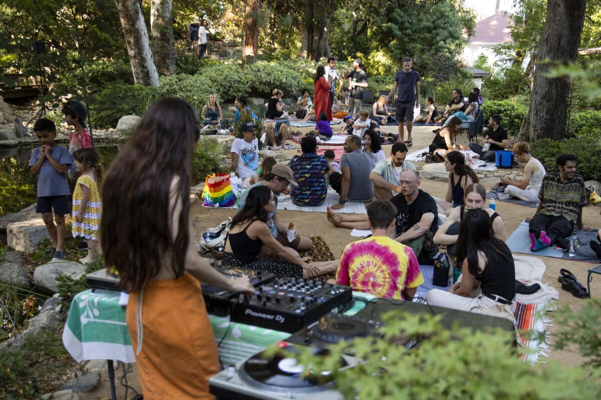 A DJ performs for a group in a garden 