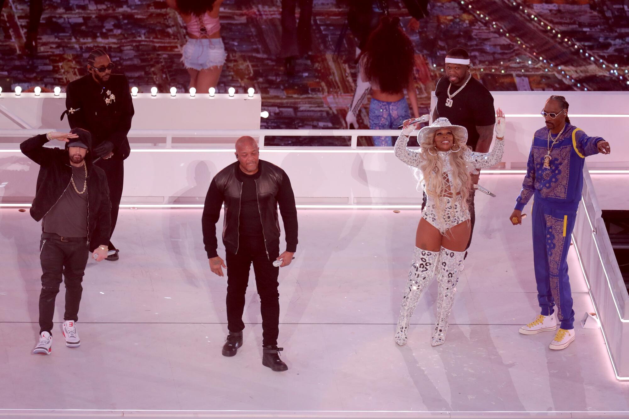 Six performers stand on a stage.