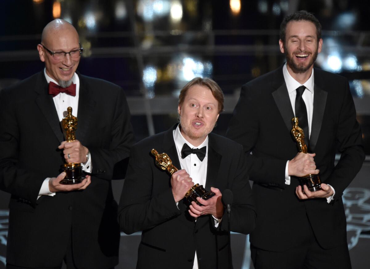 Roy Conli, left, Don Hall and Chris Williams accept the animated feature film Oscar for "Big Hero 6."