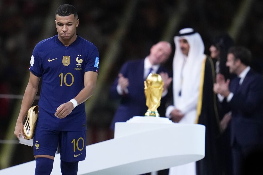 En foto del 18 de diciembre del 2022, Kylian Mbappe de Francia carga con la Bota de Oro durante la ceremonia después de que Argentina superó a Francia en la final de la Copa Mundial de Qatar. (AP Foto/Natacha Pisarenko)