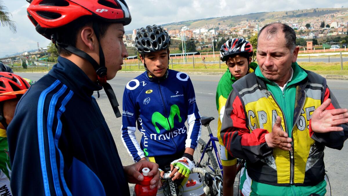 Fabio Casas, right, a trainer at the Santiago de Tunja cycling club, instructs Steven Motavita and other riders during an October practice in Boyaca, Colombia.