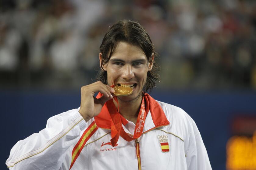 ARCHIVO - El español Rafael Nadal muerde la medalla de oro tras vencer al chileno Fernando González en la final de los Juegos Olímpicos de Beijing, el 17 de agosto de 2008. (AP Foto/Elise Amendola)