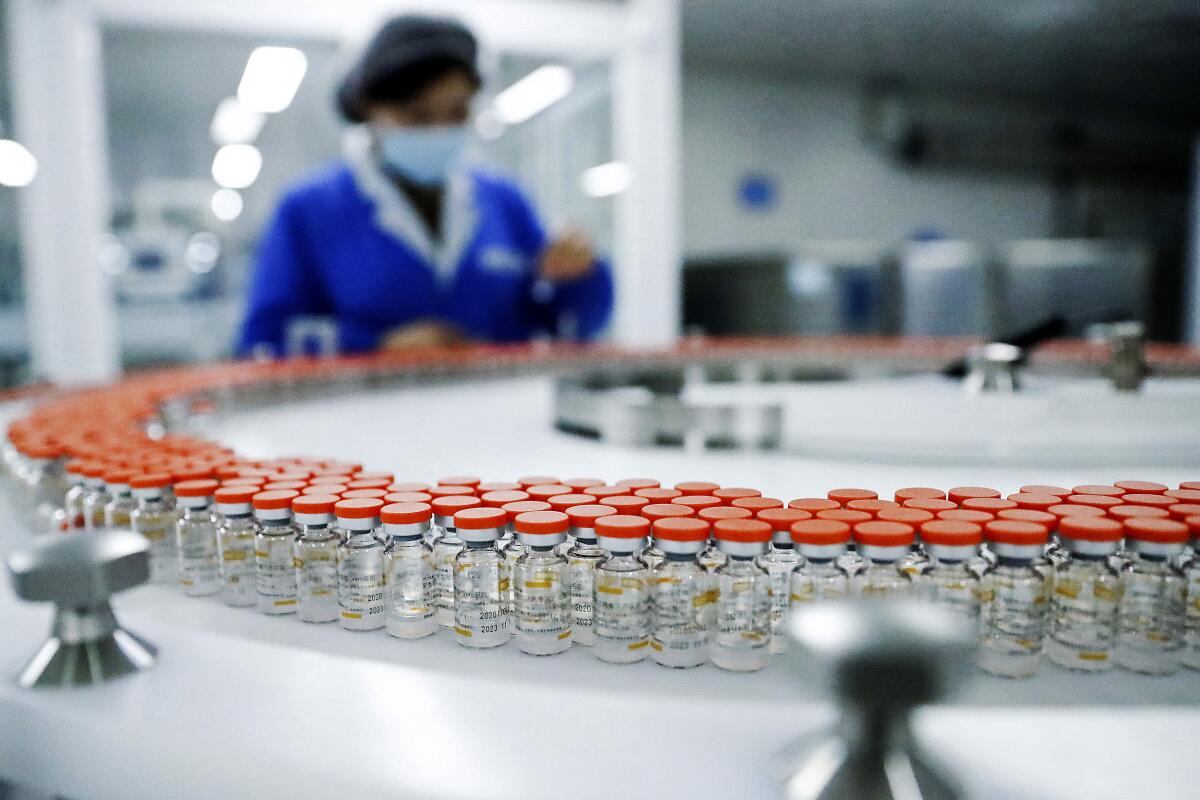 A Sinovac worker checks the labeling on vials of COVID-19 vaccines on a packaging line in Beijing.