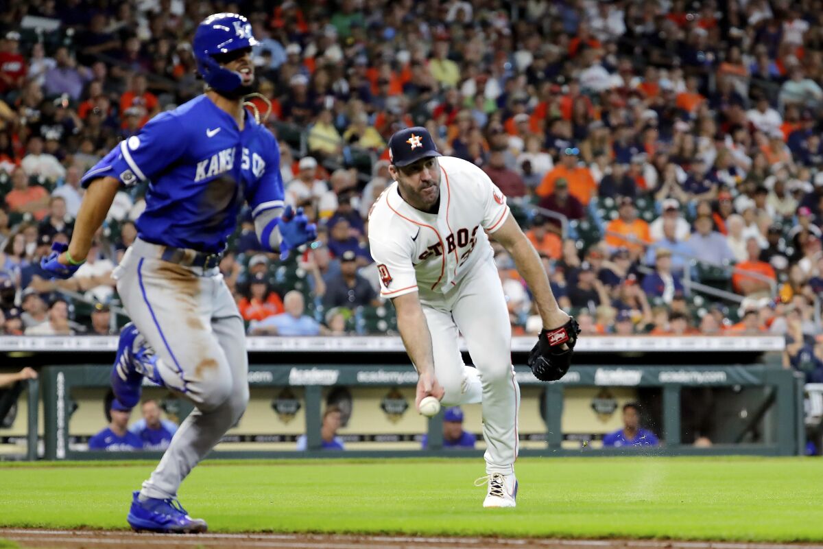 Houston Astros starting pitcher Justin Verlander, right, fields the infield grounder by Kansas City Royals designated hitter MJ Melendez, left, for the out during the fifth inning of a baseball game Thursday, July 7, 2022, in Houston. (AP Photo/Michael Wyke)