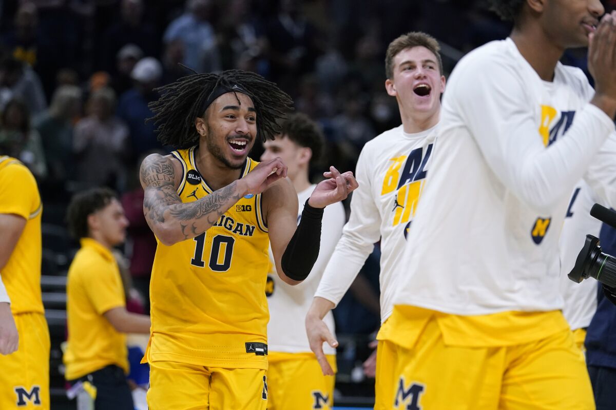 Michigan guard Frankie Collins (10) celebrates with teammates at the end of a college basketball game against Colorado State in the first round of the NCAA tournament in Indianapolis, Thursday, March 17, 2022. Michigan won 75-63. (AP Photo/Michael Conroy)